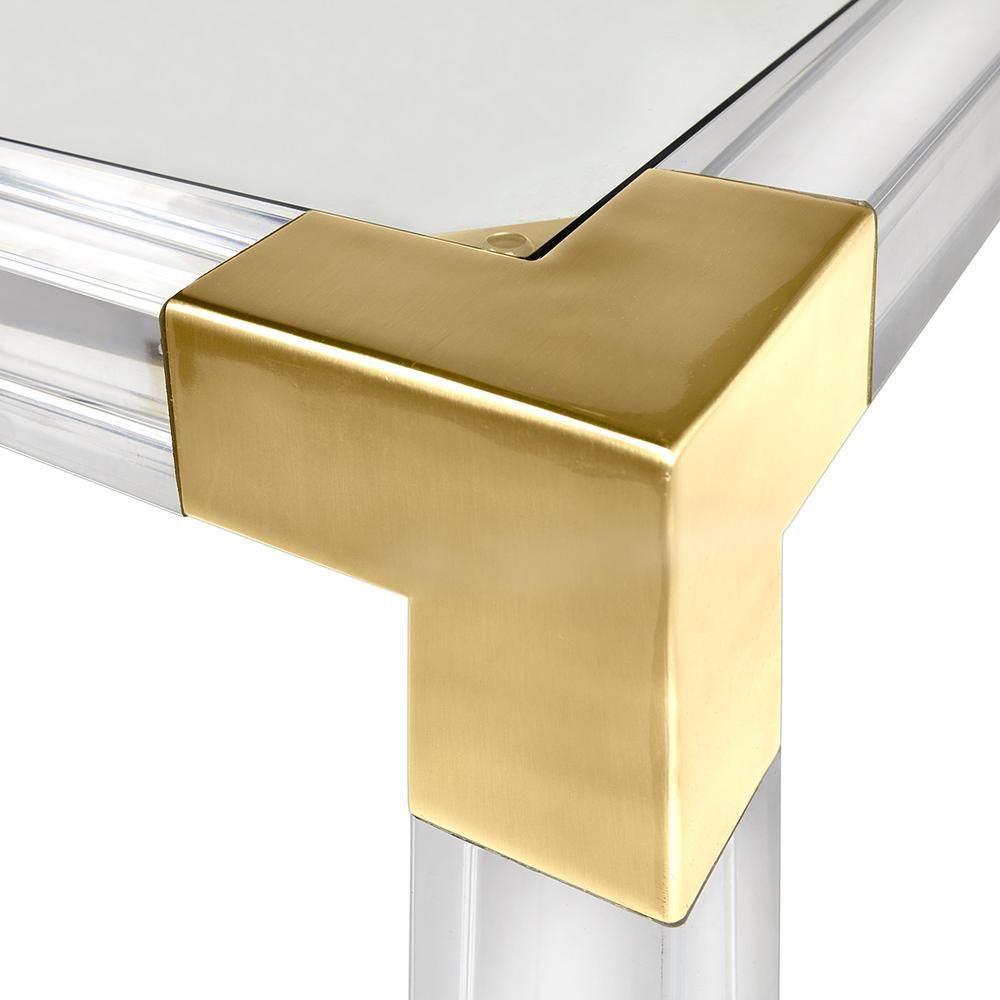 A contemporary brass and acrylic games tale with a glass surface