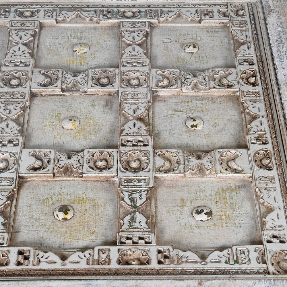 Intricately carved dining table in a light washed-wood