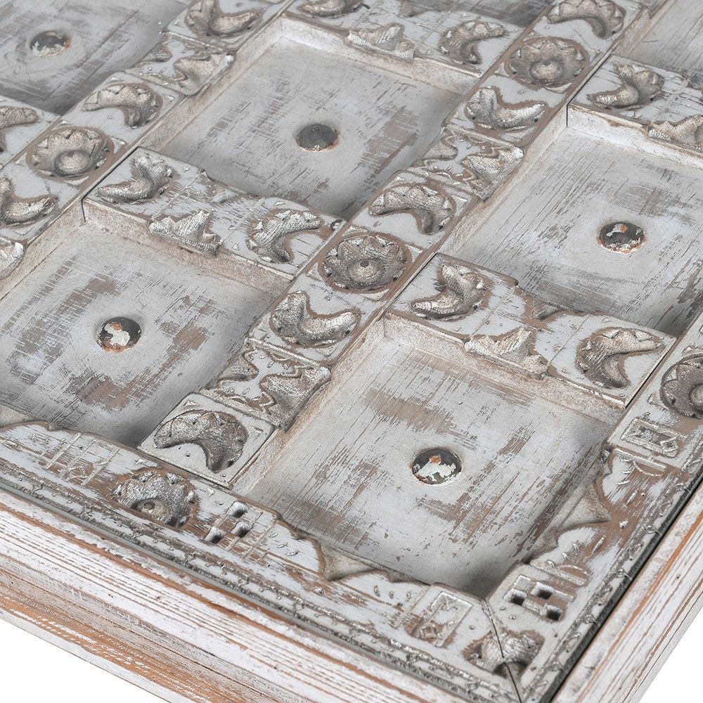 washed wood side table with intricate carved detailing