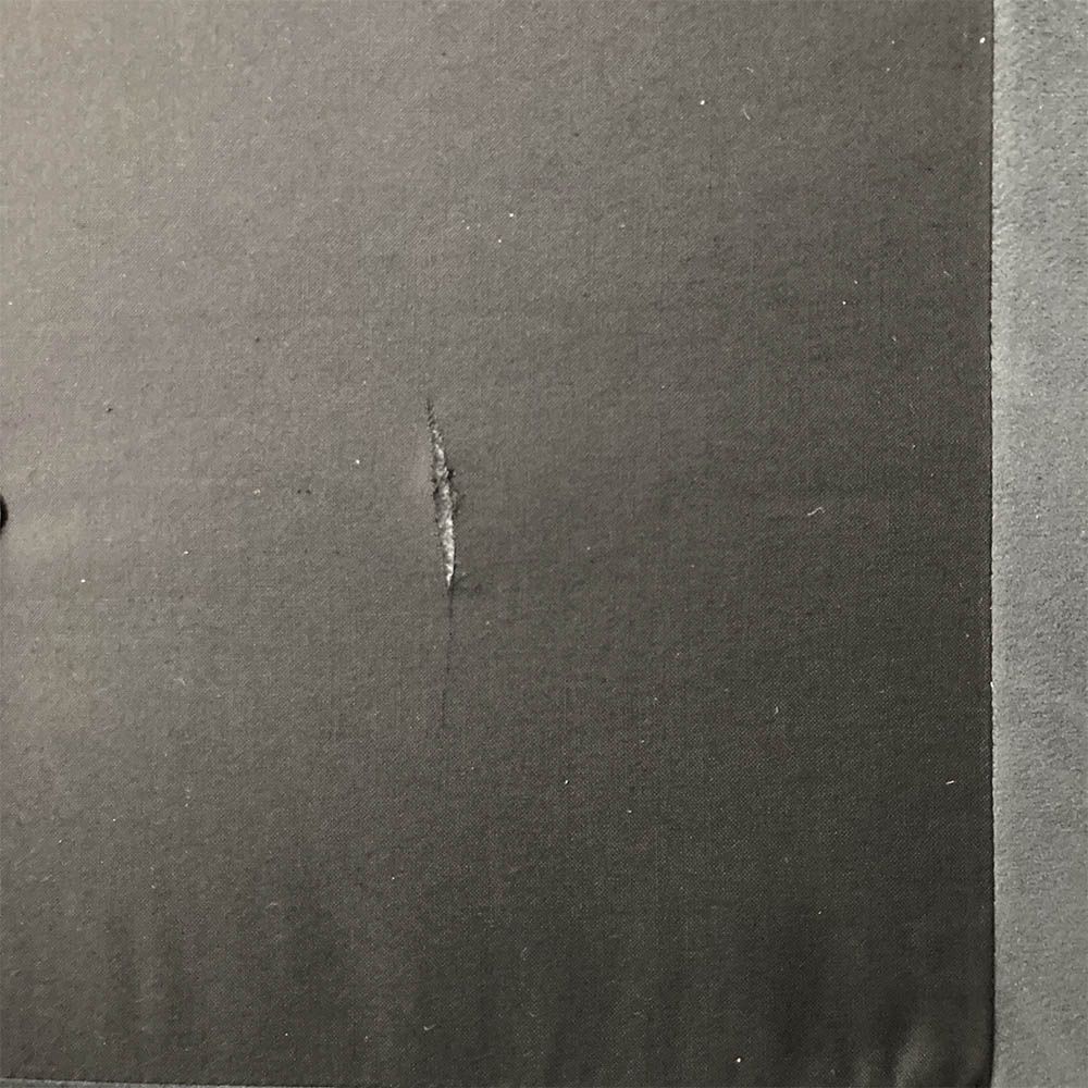 Tear in divan fabric on top right of the bed