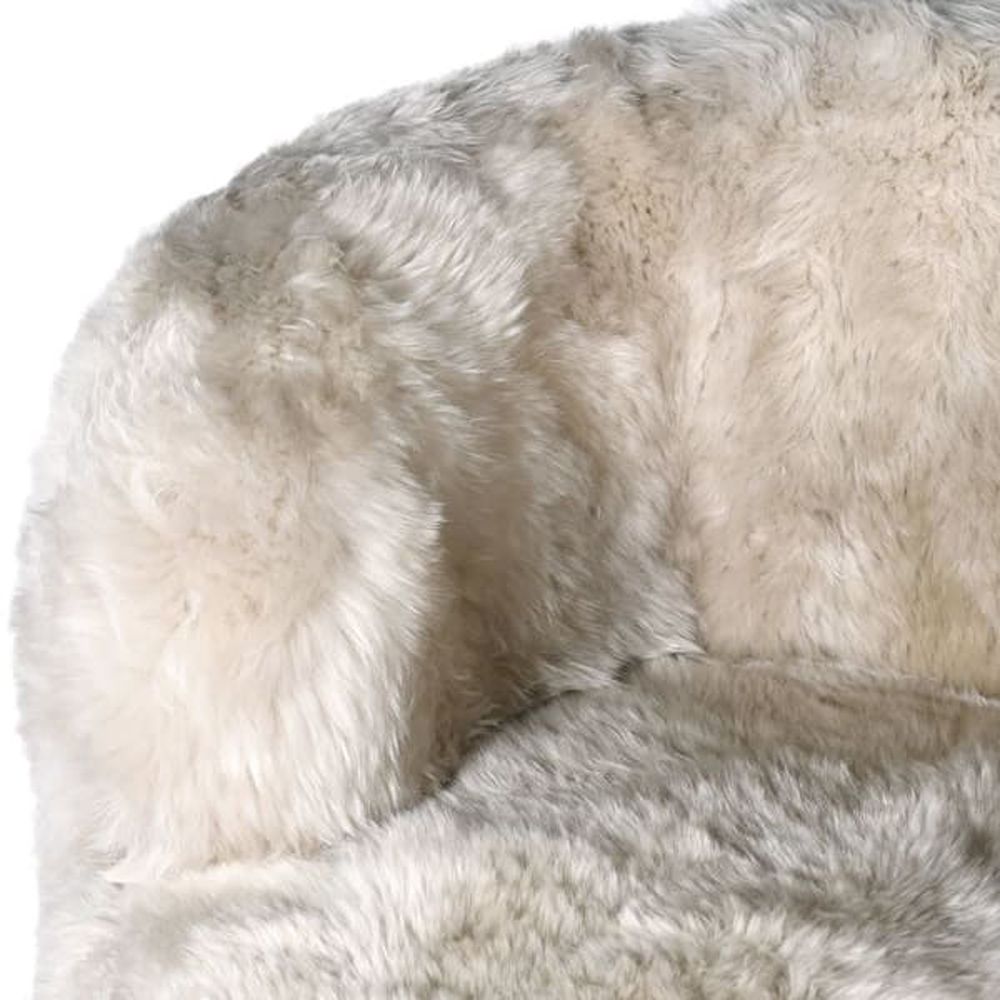 a luxurious cream-coloured fur armchair with golden tapered legs