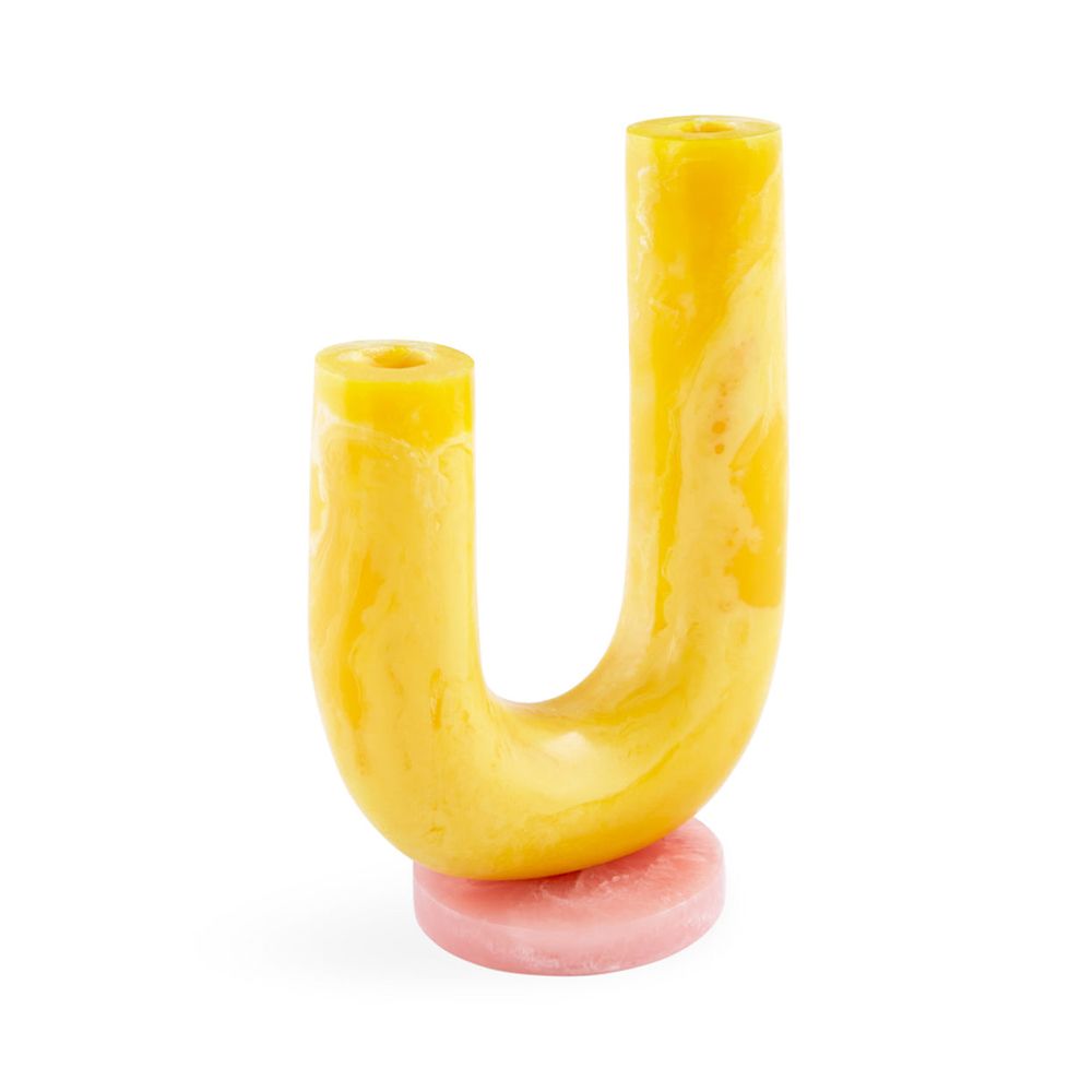 A stylish vase by Jonathan Adler featuring a geometric shape with tones of yellow and pink and a polished marbleized finish
