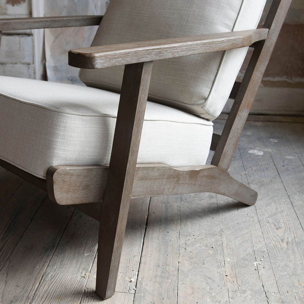 A stylish armchair with an ash wood frame and soft cream upholstery 