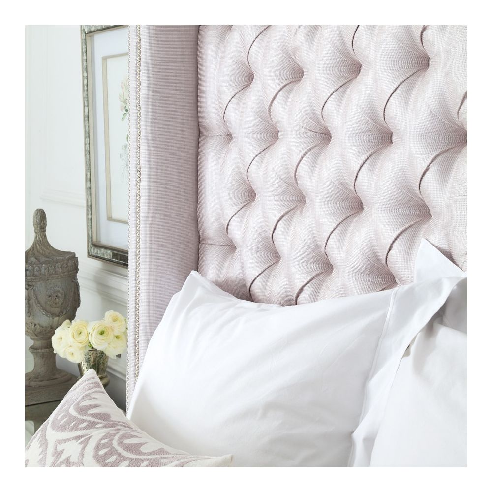 Luxury hotel-style bed with tall deep buttoned headboard and stud detailing