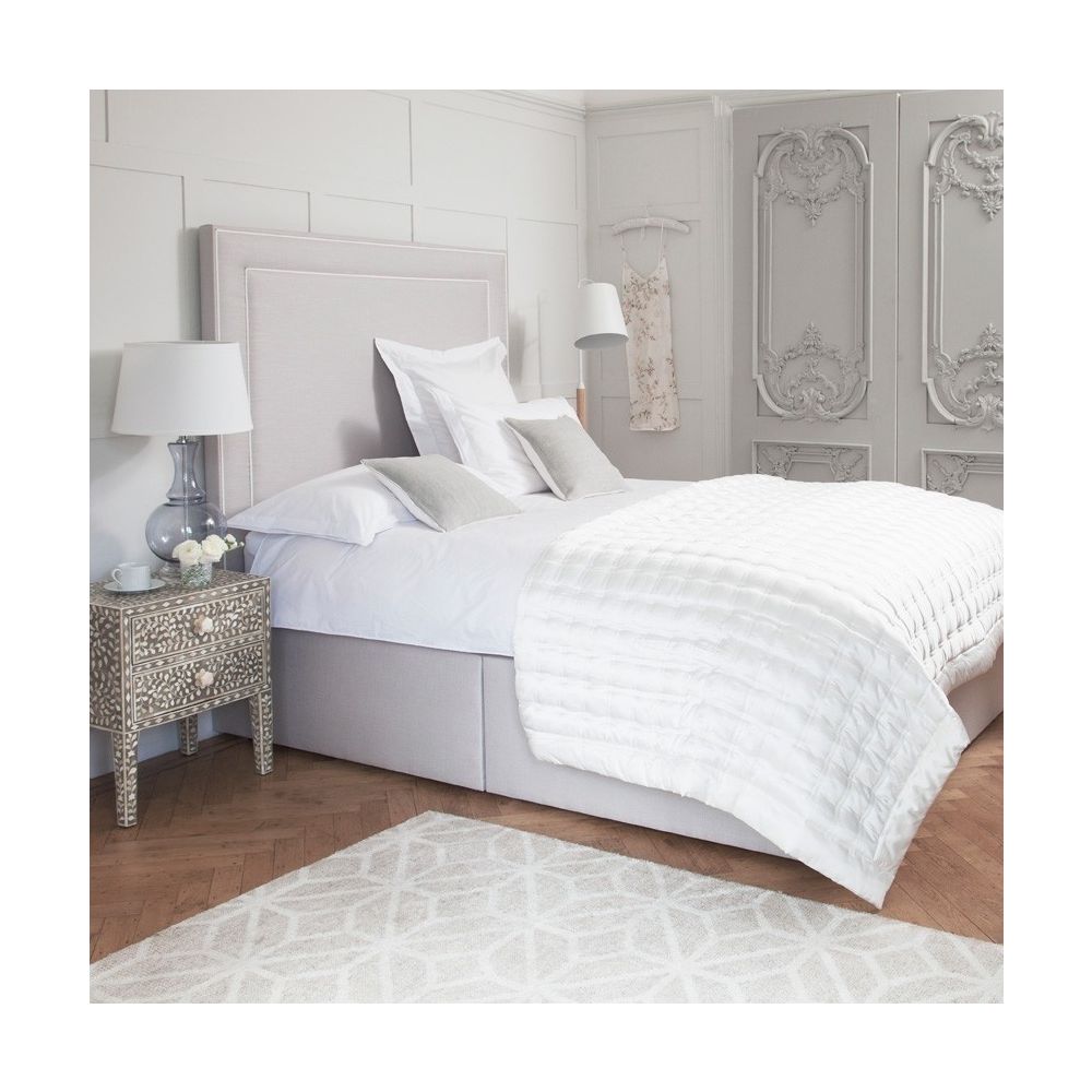 Luxury designer bed with tall headboard and piping detail