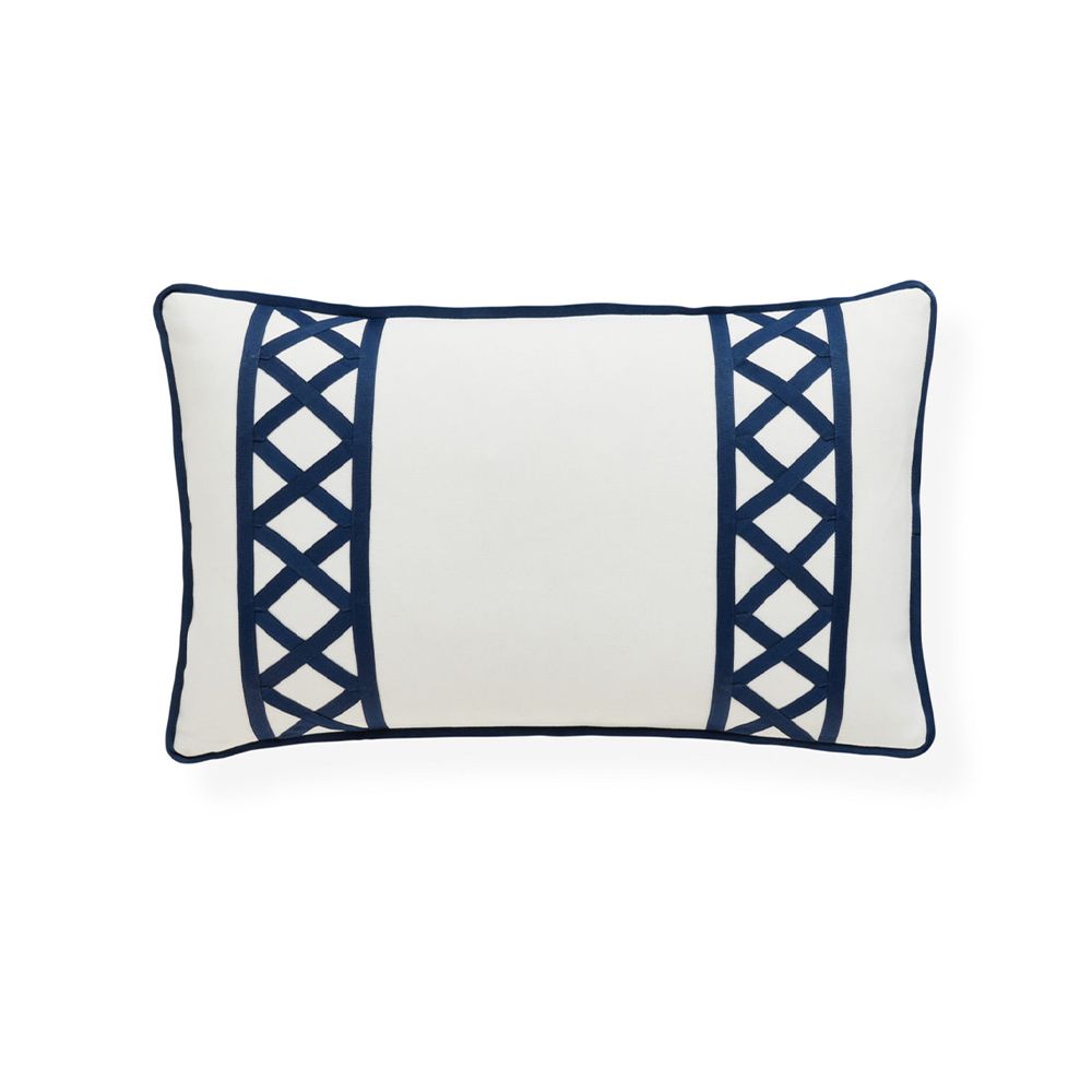 A stylish, rectangular outdoor cushion by Jonathan Adler with an ivory cover and navy raised grosgrain ribbon embroidery