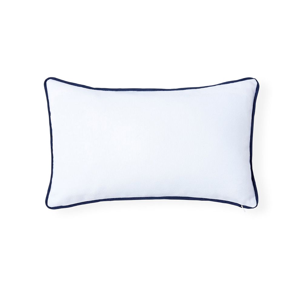 A stylish, rectangular outdoor cushion by Jonathan Adler with an ivory cover and navy raised grosgrain ribbon embroidery