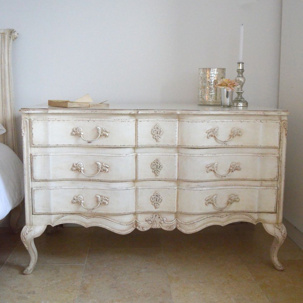A french inspired chest of drawers with carved details.