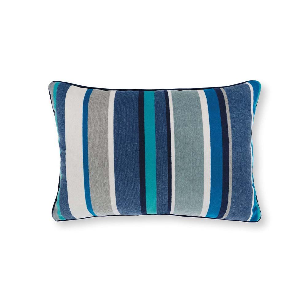 A blue velvet outdoor cushion with various stripes with complementary dark blue piping.
