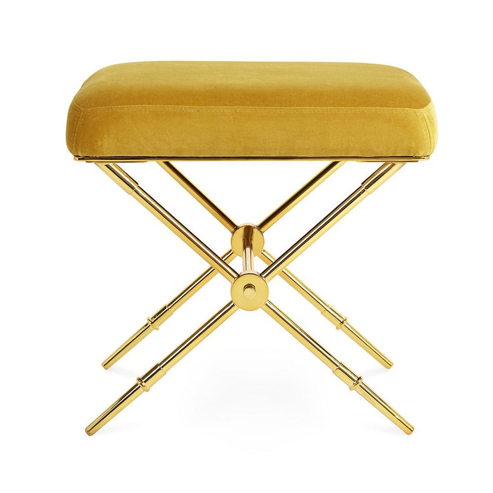 A luxurious stool with golden velvet and a brass base