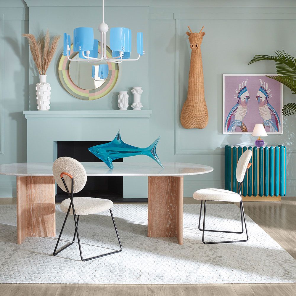 A luxurious dining table by Jonathan Adler with a white Carrara marble top and T-shaped legs crafted from solid oak