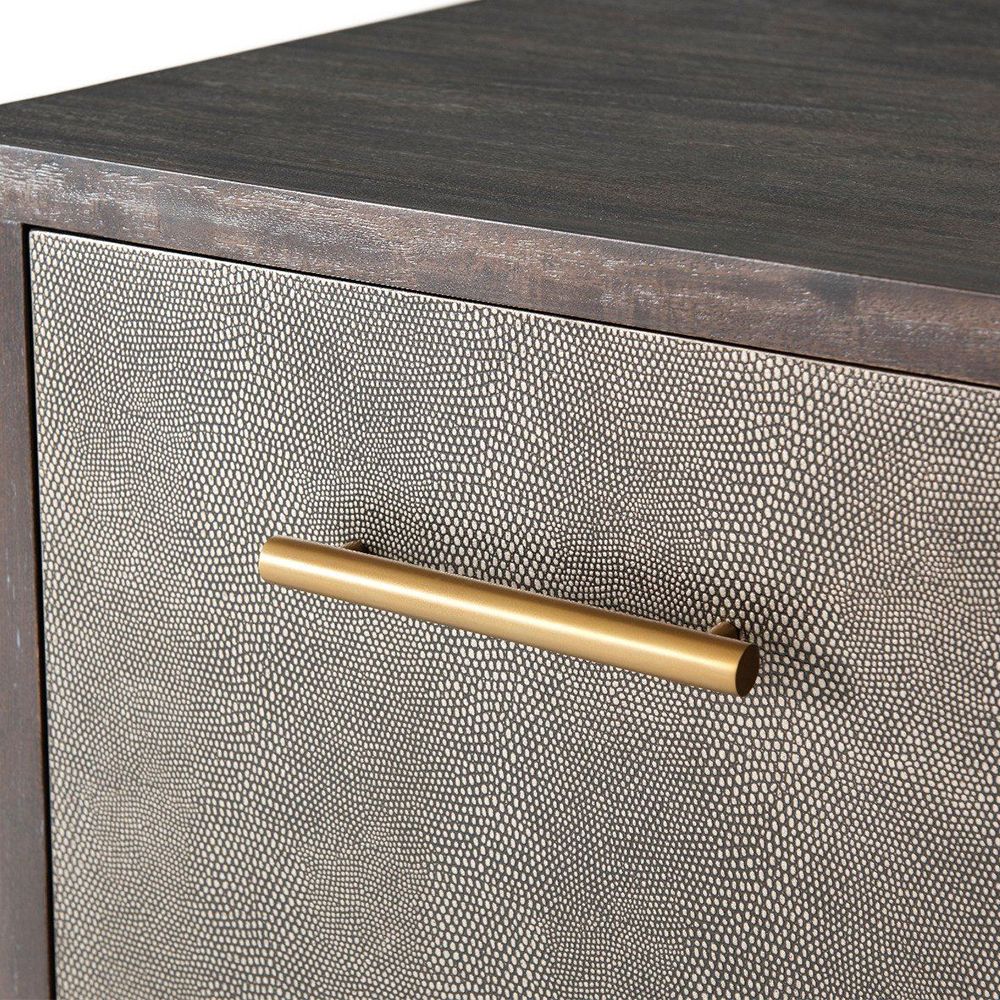 A luxurious chest with three textured drawers covered in embossed leather and finished with brushed brass handles