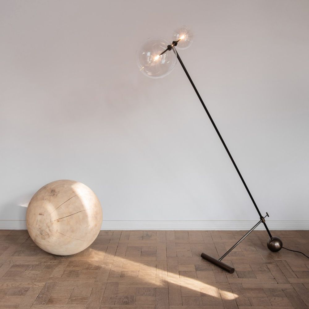 Black gunmetal brass industrial style floor lamp with angled, adjustable frame and clear glass globe lampshades
