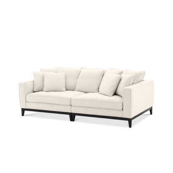 A luxurious cream coloured sofa with a black base and feet