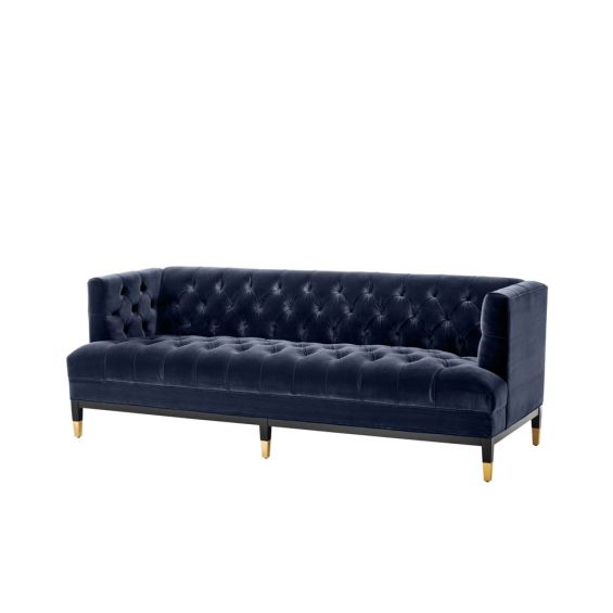 dark blue deep-buttoned sofa with velvet upholstery and black legs with gold accents