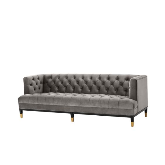 grey deep-buttoned sofa with velvet upholstery and black legs with gold accents