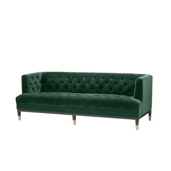 green velvet upholstered deep-buttoned sofa with black legs and brass accents 