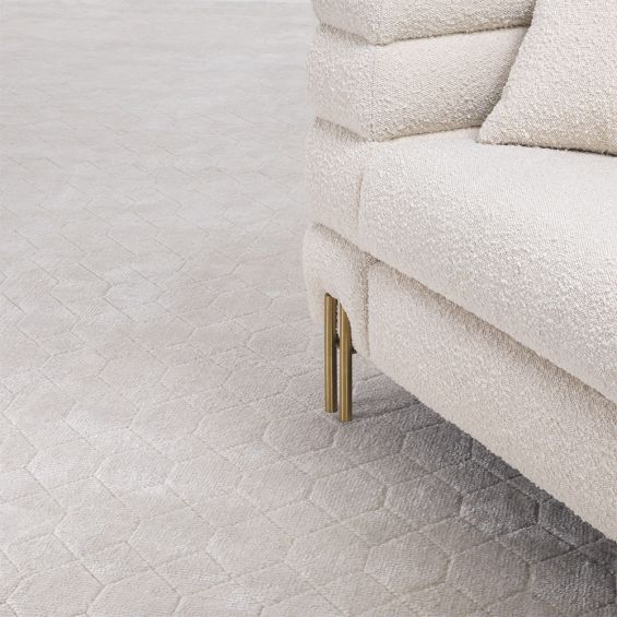 A luxury rug by Eichholtz with a geometric, honeycomb-like pattern and natural finish 