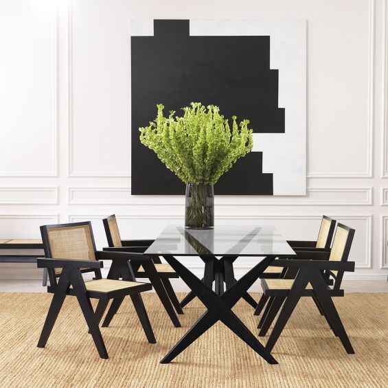 An iconic, black Jeanneret-inspired dining chair with a rattan seat and backrest