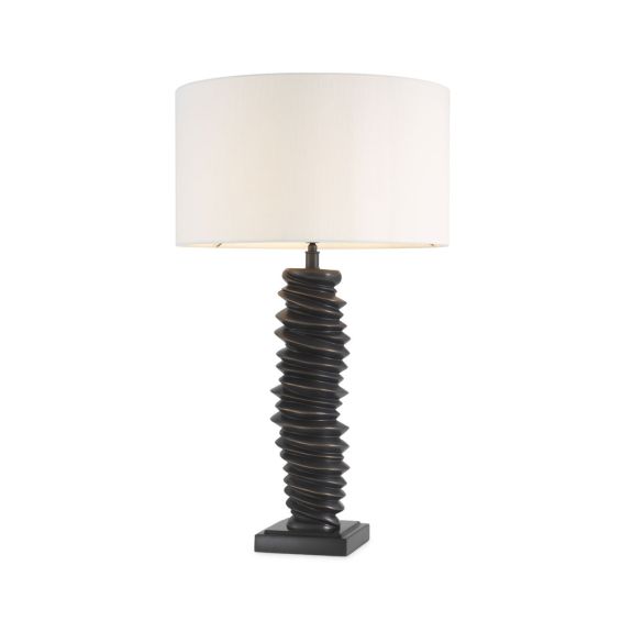 A luxurious bronze table lamp with a natural-toned lampshade