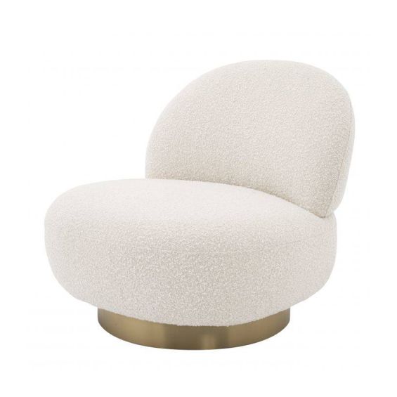 A luxurious boucle armchair with a brushed brass swivel base