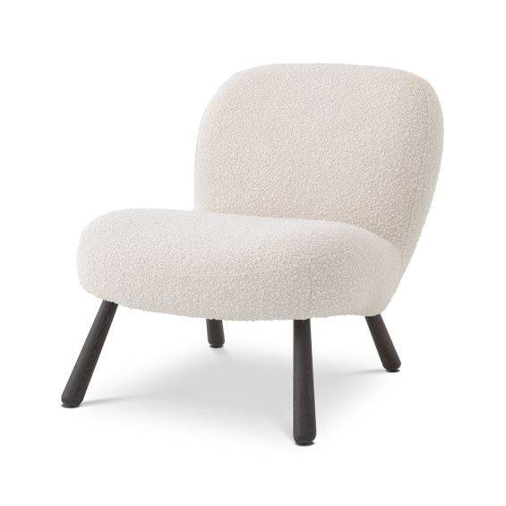 A luxurious boucle cream armchair with splayed, wooden legs