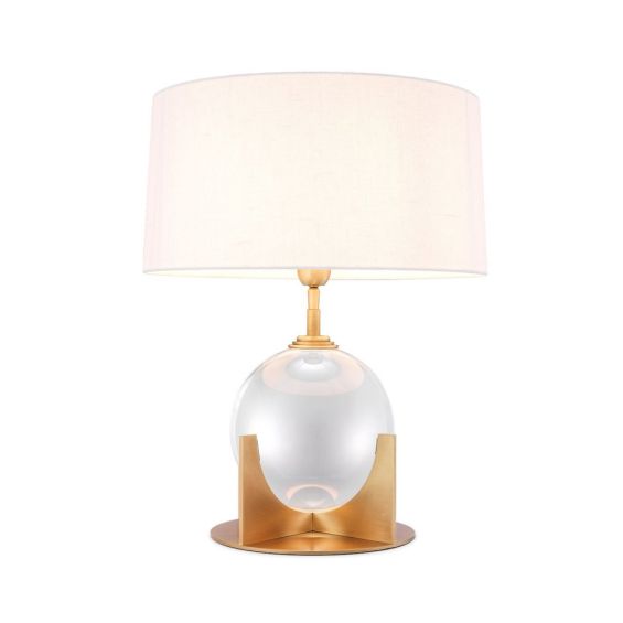A luxurious crystal glass table lamp with a brushed brass base