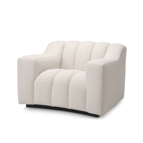 A stylish cream boucle armchair with deep-channelled details and a black base