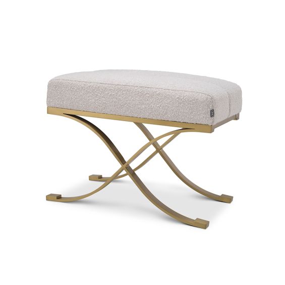 A glamorous stool by Eichholtz with a luxurious boucle cream upholstery and a lustrous brushed brass finish