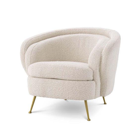 boucle cream armchair with brass legs.