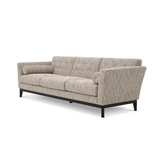A Mid-Century inspired sofa by Eichholtz with a luxurious beige upholstery, tufting, curved armrests and a sleek black base