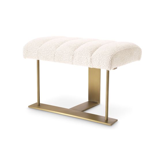 A gorgeous stool by Eichholtz with a boucle cream upholstery, deep channelled stitching and a brushed brass frame