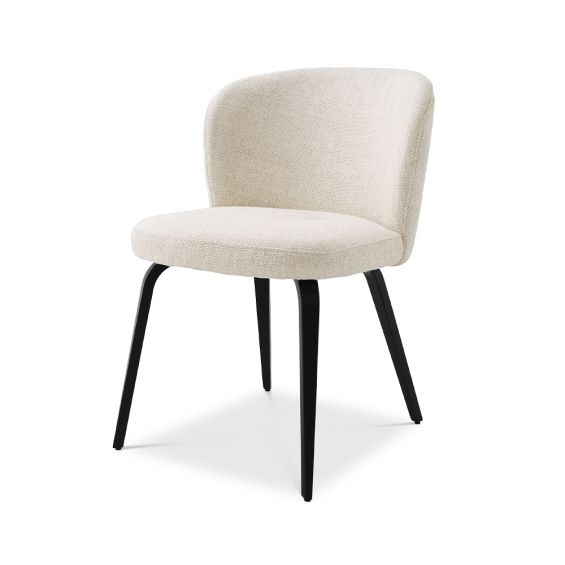 A gorgeous dining chair by Eichholtz with an arched back, tapered black legs and a Pausa Natural upholstery