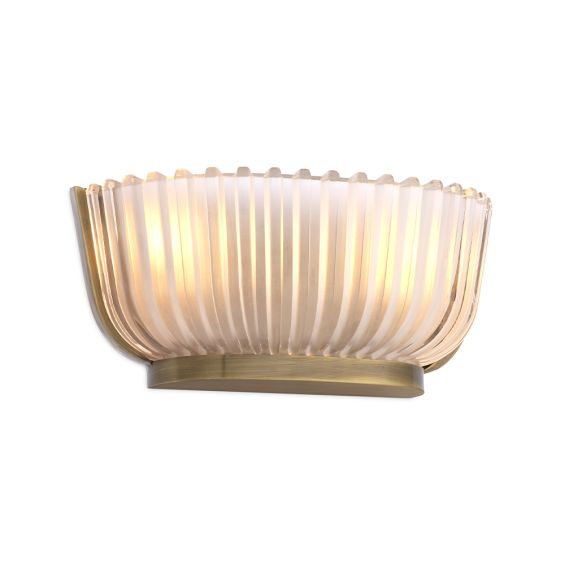 A luxurious wall lamp by Eichholtz featuring a frosted glass shade with vertical lines and a vintage brass finish