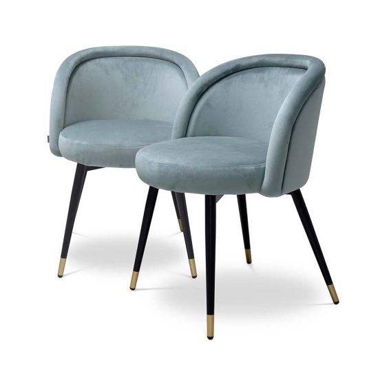 Pair of blue velvet dining chairs with black legs and brass tipped feet.
