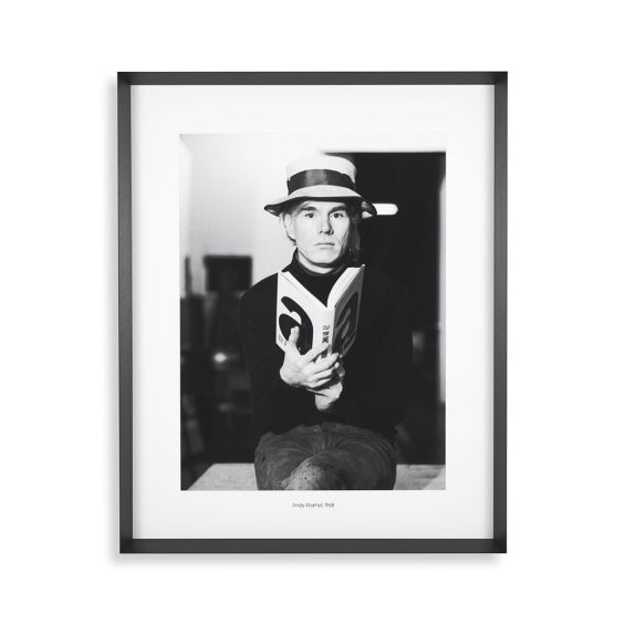 Portrait of Andy Warhol with his novel 'a,' encased in a black frame