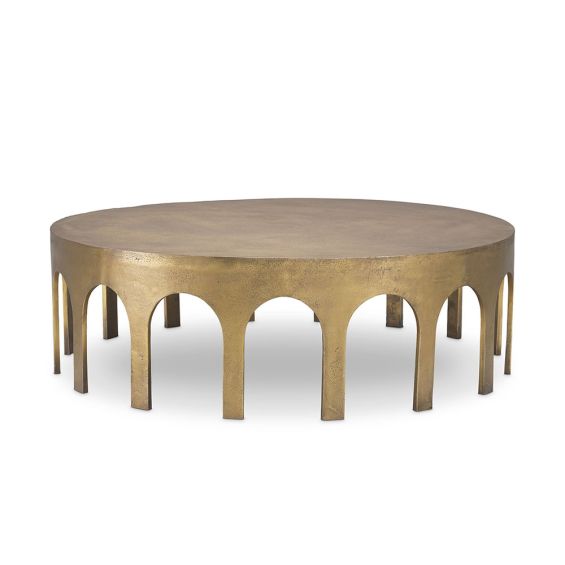 A statement coffee table by Eichholtz with arched details and a vintage brass finish