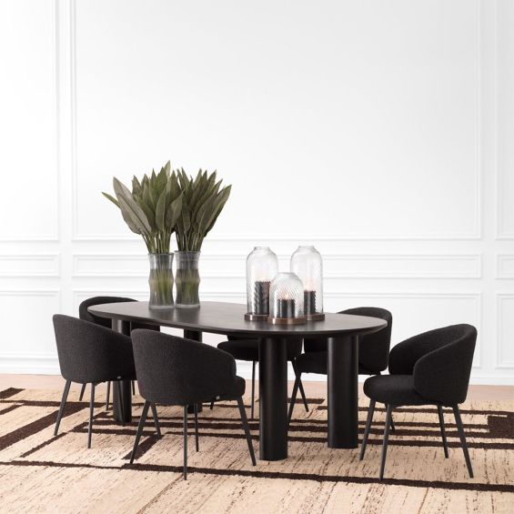A luxury black dining table by Eichholtz with offset playful legs