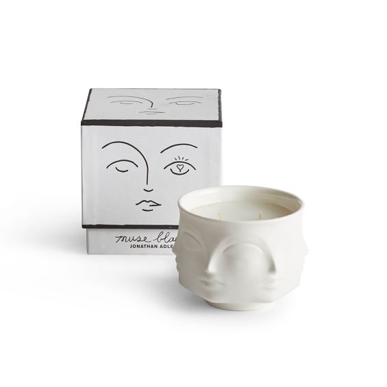 white ceramic candle decorated with faces