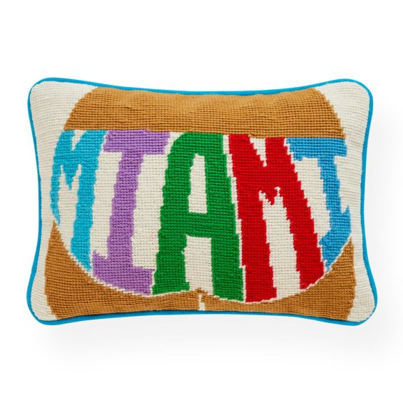 A bold and colourful cushion featuring hand embroidery and a velvet back
