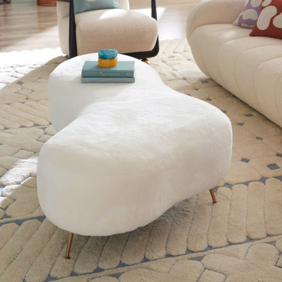 Organic shaped upholstered ottoman with tapered brass legs