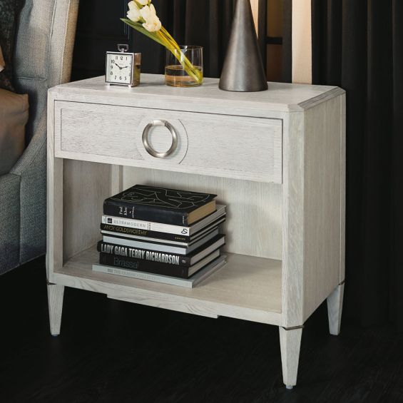 A stylish natural wood bedside table with nickel hardware