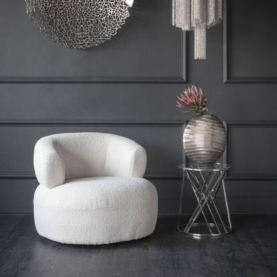 A contemporary armchair with a beautiful boucle cream upholstery and contrasting black feet