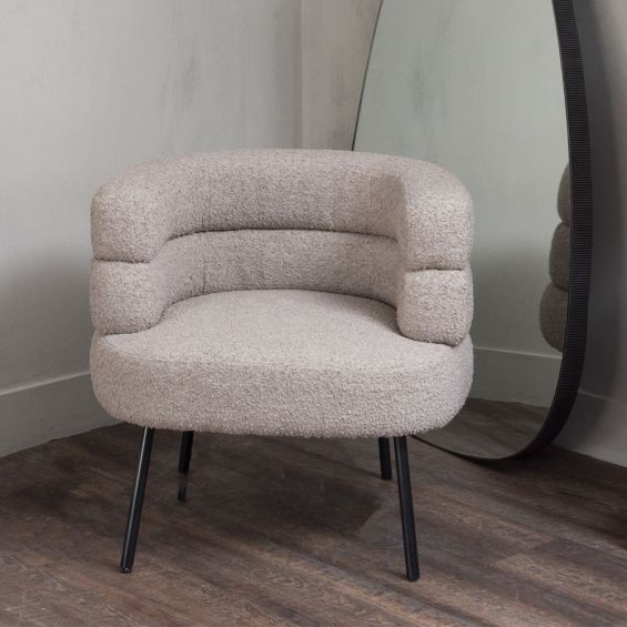 A Mid-Century Modern armchair with Art-Deco influences, a stylish silhouette and a taupe bouclé upholstery 
