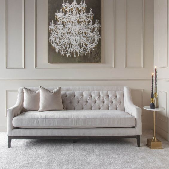 Classic deep-buttoned sofa in ivory finish with curved armrests