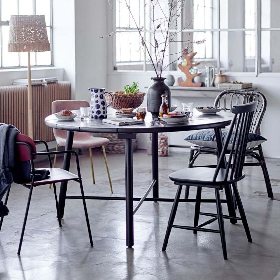 A sophisticated, rounded dining table made from black stained acacia wood