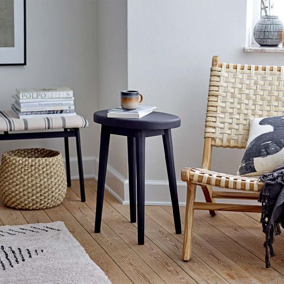 A black ovular shaped, side table crafted from mango wood