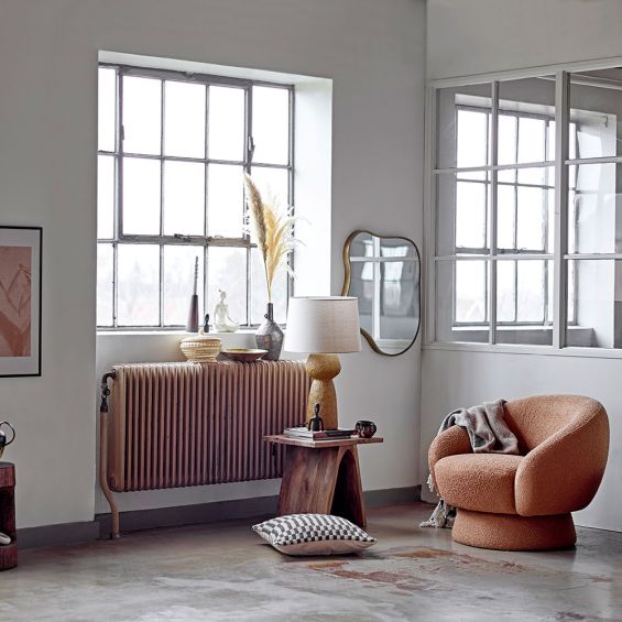 A curvaceous free-flowing wall mirror with an organic shape and brushed brass frame 