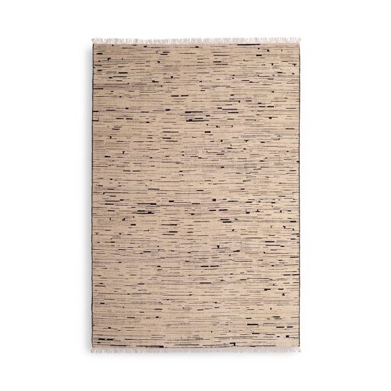 textured cream rug with black specs and a fringe