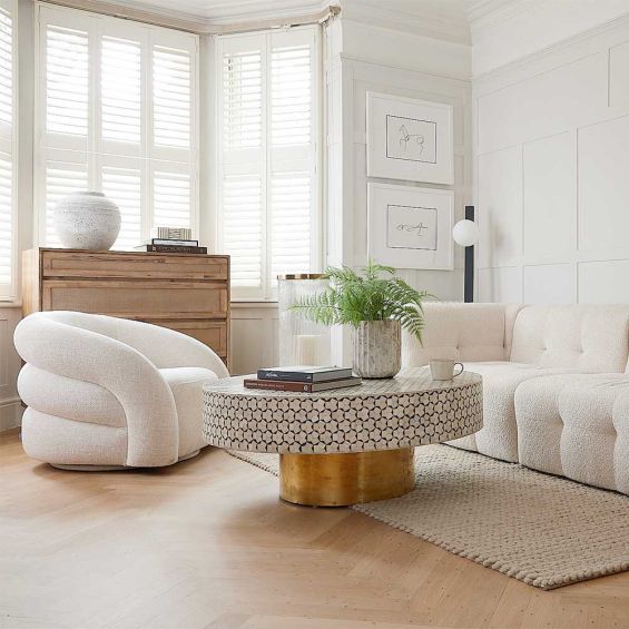 A luxury bone inlay coffee table with a round and geometric design elevated on a brass base